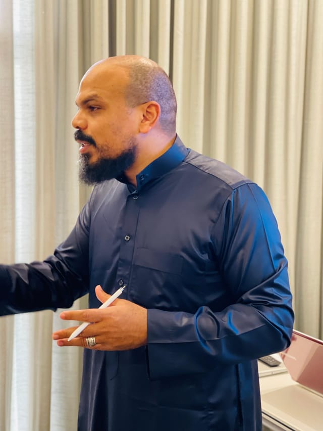 أ/ محمد ريان أثناء الشرح في قاعة التدريب، وفي يده قلم.